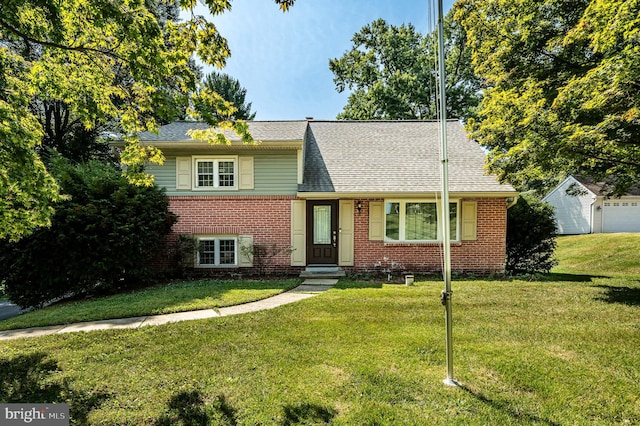 tri-level home with an outdoor structure, a garage, and a front lawn