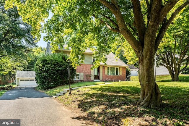 view of front of property with an outbuilding, a garage, and a front lawn