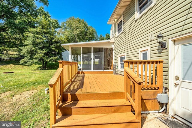 wooden deck with a sunroom and a lawn