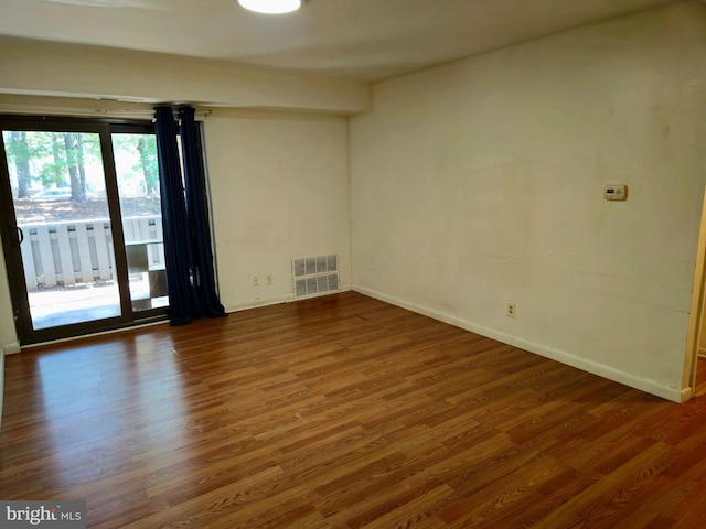 empty room with dark hardwood / wood-style flooring