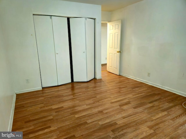 unfurnished bedroom with light hardwood / wood-style flooring and a closet