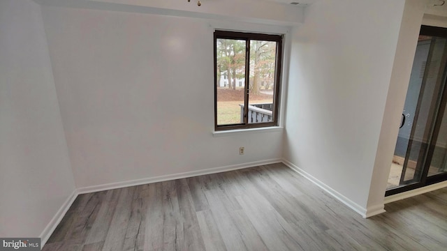 unfurnished room with plenty of natural light and wood-type flooring