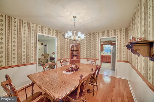 dining space featuring light hardwood / wood-style flooring and a chandelier