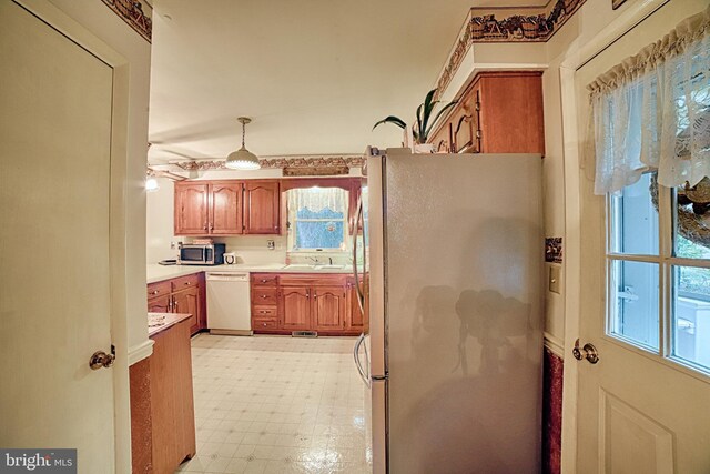 kitchen with appliances with stainless steel finishes and decorative light fixtures