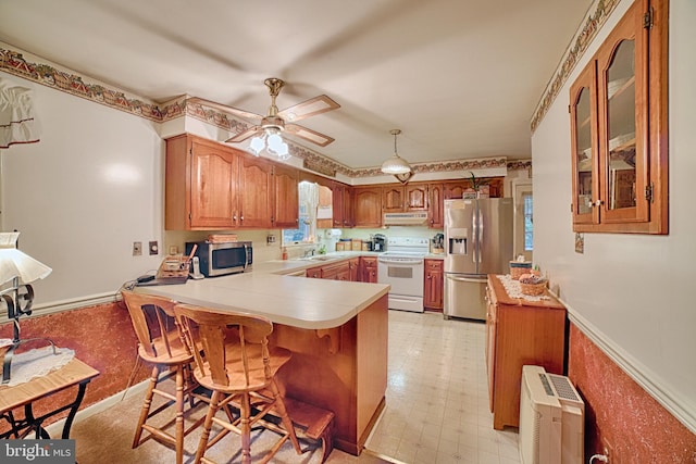 kitchen with ceiling fan, sink, kitchen peninsula, decorative light fixtures, and appliances with stainless steel finishes