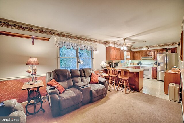 living room featuring a barn door, light carpet, and ceiling fan