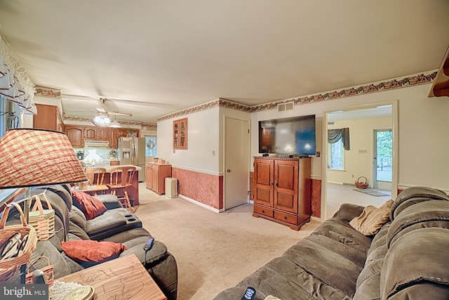 carpeted living room with ceiling fan