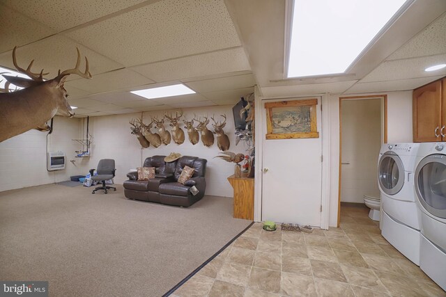 clothes washing area featuring washer and clothes dryer, light carpet, and heating unit