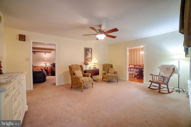 living area with ceiling fan and light carpet