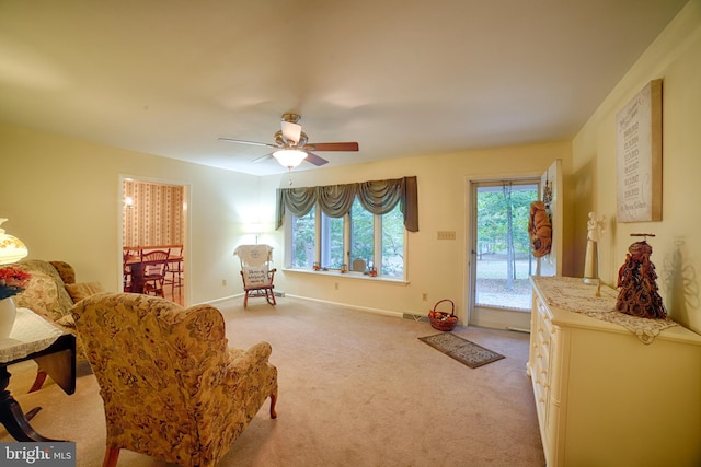 living area with ceiling fan and light colored carpet