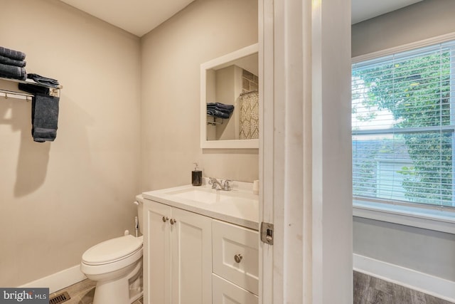 bathroom featuring wood-type flooring, vanity, and toilet