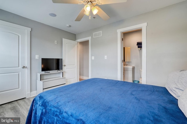 bedroom featuring light hardwood / wood-style flooring, ceiling fan, and ensuite bathroom