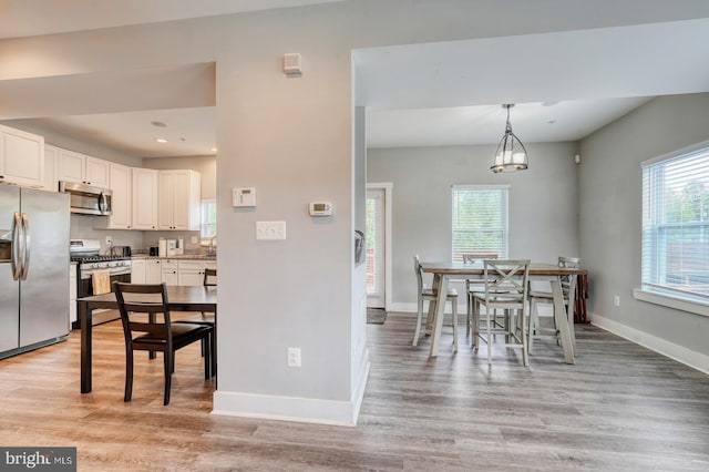 dining area with light hardwood / wood-style floors and a wealth of natural light