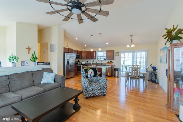 living room featuring light hardwood / wood-style flooring, vaulted ceiling, and ceiling fan