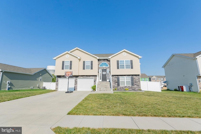 raised ranch featuring a garage and a front yard