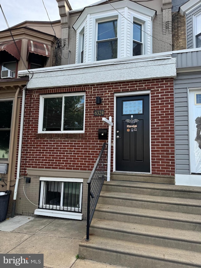 view of exterior entry featuring brick siding