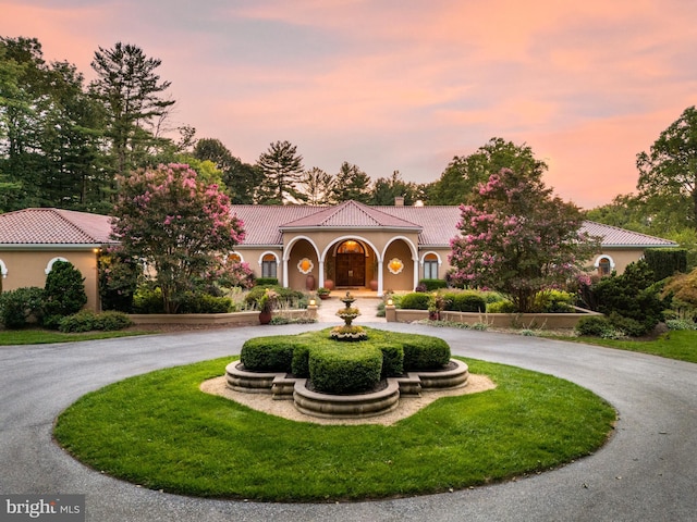 1100 Ginkgo Ln, Gladwyne, PA 19035 - mediterranean / spanish-style home featuring a chimney, stucco siding, curved driveway, and a tile roof