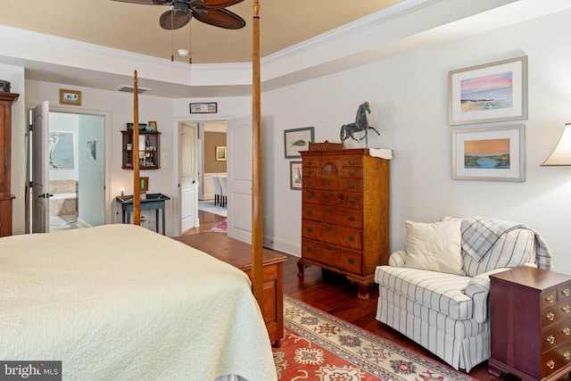 bedroom with ornamental molding, ensuite bath, dark wood-type flooring, and ceiling fan