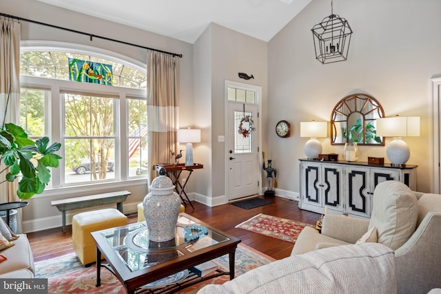 living room with dark hardwood / wood-style flooring, high vaulted ceiling, and a healthy amount of sunlight