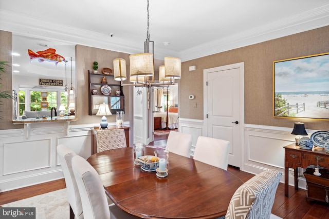 dining space with crown molding, dark wood-type flooring, and a chandelier