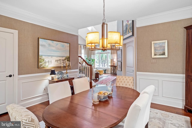 dining space with a notable chandelier, crown molding, and hardwood / wood-style floors