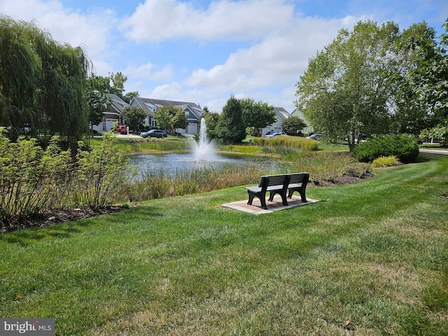 surrounding community featuring a water view and a yard