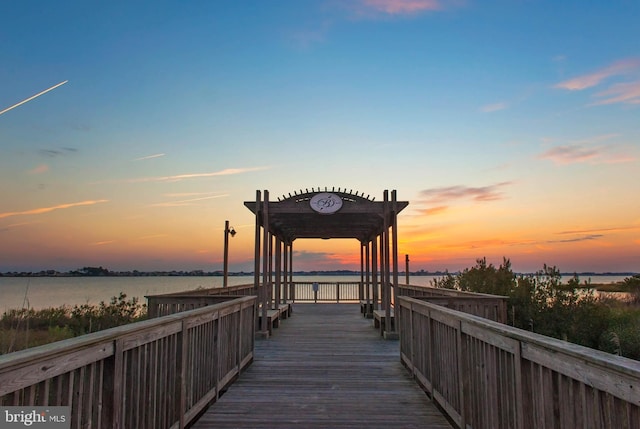 view of dock with a pergola and a water view