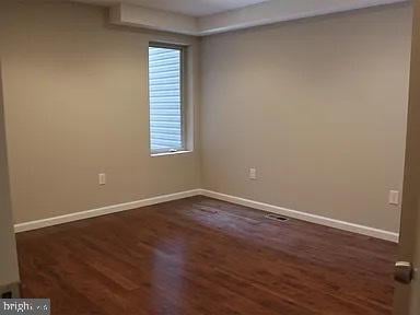 unfurnished room with dark hardwood / wood-style floors