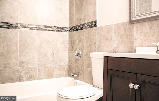 full bathroom with shower / tub combination, tile walls, toilet, and vanity