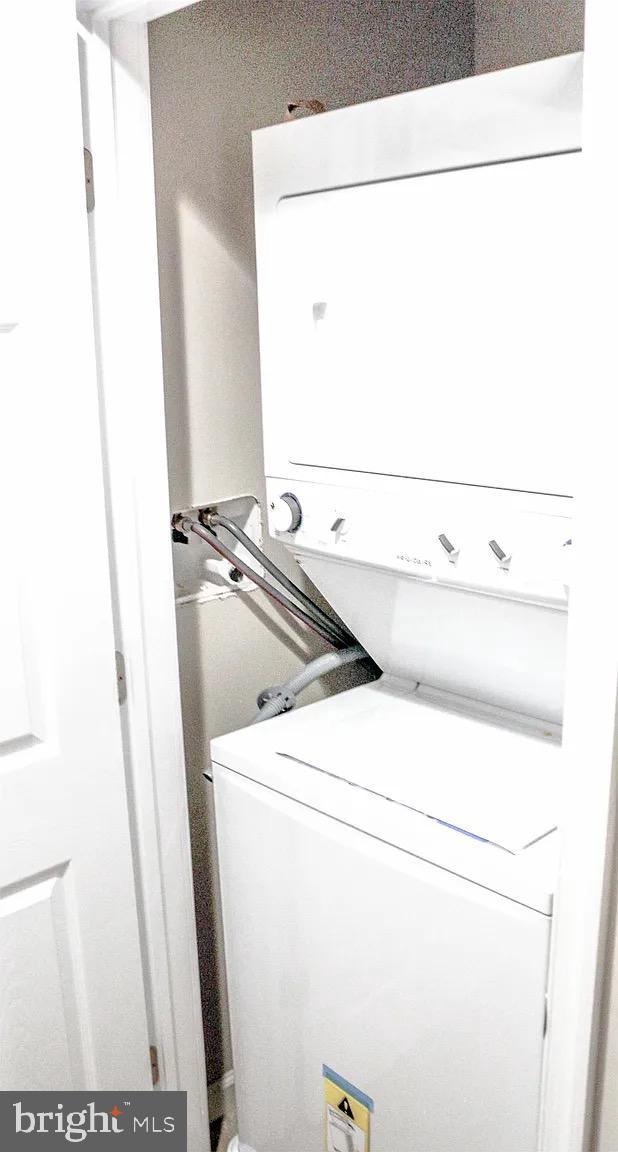 washroom with laundry area and stacked washer / drying machine