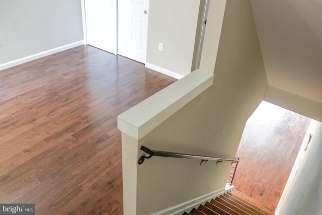 stairway with baseboards and wood finished floors