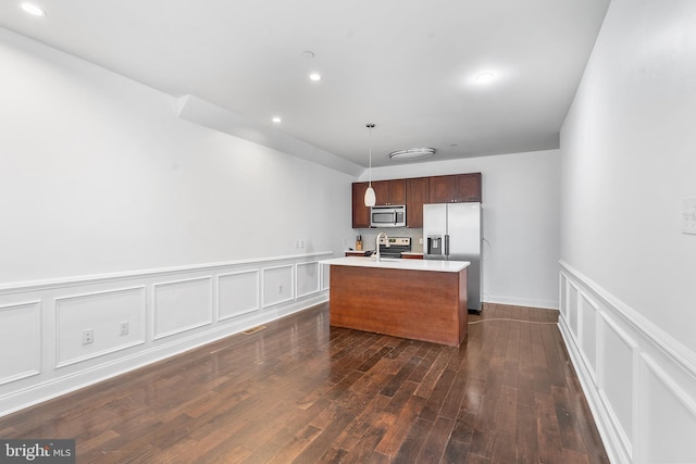 kitchen with dark hardwood / wood-style floors, a kitchen island with sink, stainless steel appliances, and hanging light fixtures