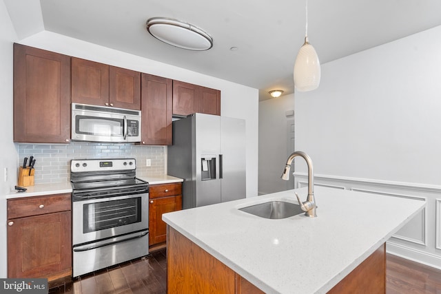 kitchen with a center island with sink, sink, stainless steel appliances, and dark hardwood / wood-style floors