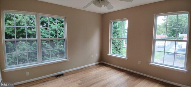 unfurnished room featuring plenty of natural light, ceiling fan, and light hardwood / wood-style floors