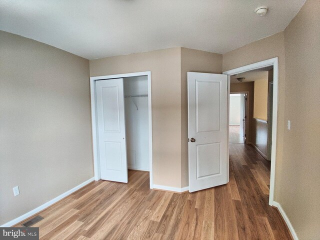 unfurnished bedroom featuring hardwood / wood-style flooring and a closet