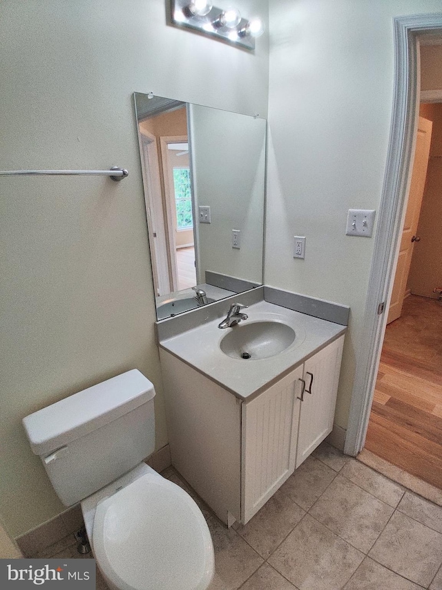 bathroom with vanity, toilet, and wood-type flooring