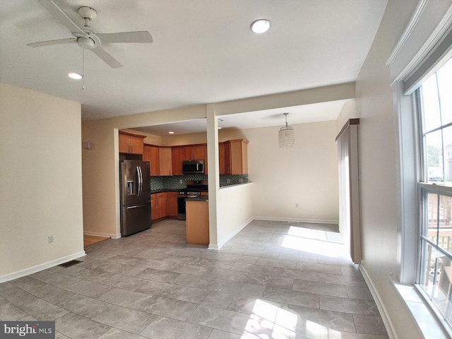 kitchen featuring hanging light fixtures, stainless steel appliances, ceiling fan, and tasteful backsplash