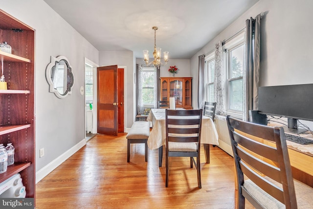 dining space featuring a chandelier and light wood-type flooring