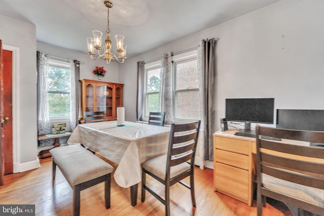 dining area featuring light hardwood / wood-style floors and an inviting chandelier