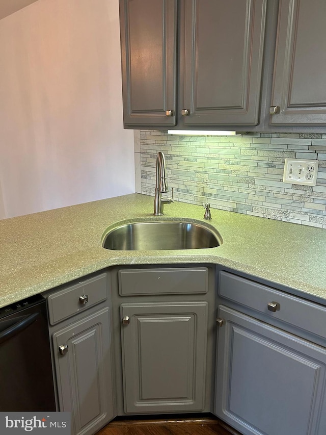 kitchen with gray cabinetry, tasteful backsplash, sink, dishwasher, and dark hardwood / wood-style flooring