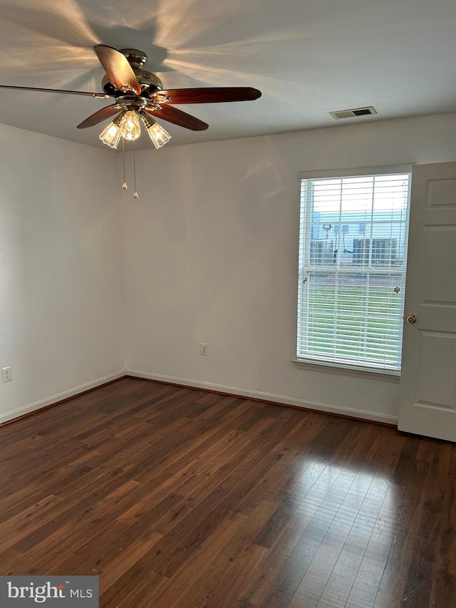 spare room featuring dark wood-type flooring and ceiling fan