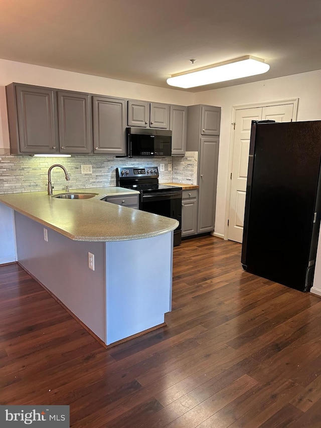 kitchen featuring kitchen peninsula, dark hardwood / wood-style floors, stainless steel appliances, and sink