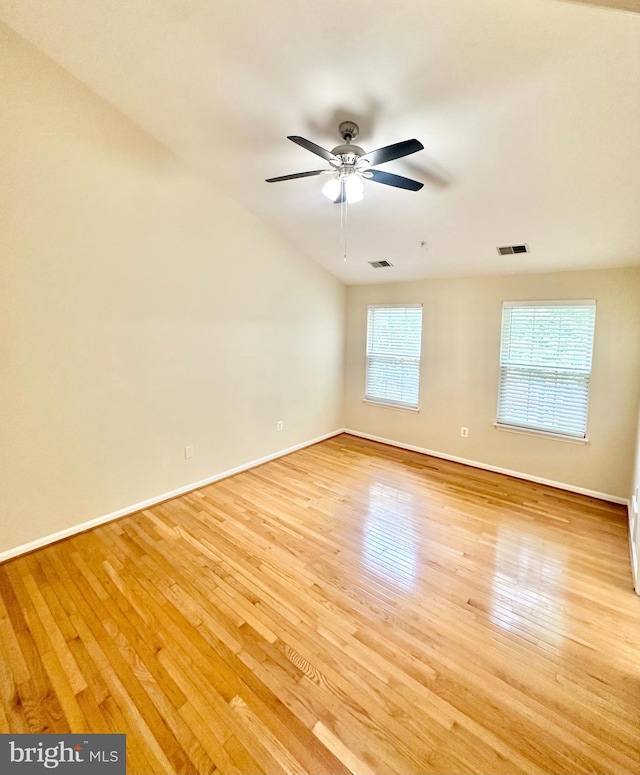 spare room with ceiling fan, light wood-type flooring, and a wealth of natural light