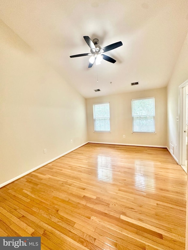 spare room featuring ceiling fan, lofted ceiling, and light wood-type flooring