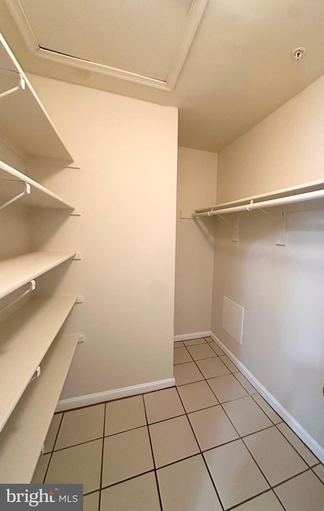 walk in closet with light tile patterned floors