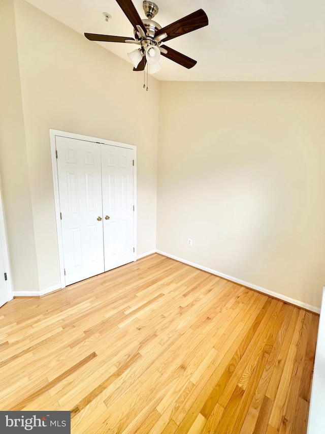 unfurnished bedroom with a closet, vaulted ceiling, light hardwood / wood-style floors, and ceiling fan