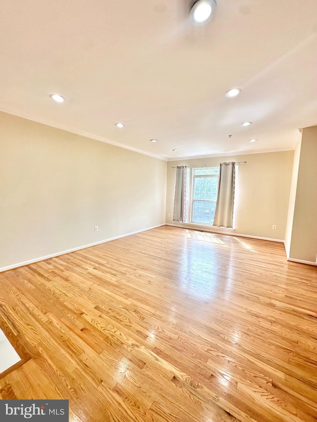 unfurnished room featuring light hardwood / wood-style floors and crown molding