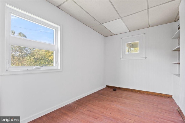 unfurnished room featuring light hardwood / wood-style flooring and a drop ceiling