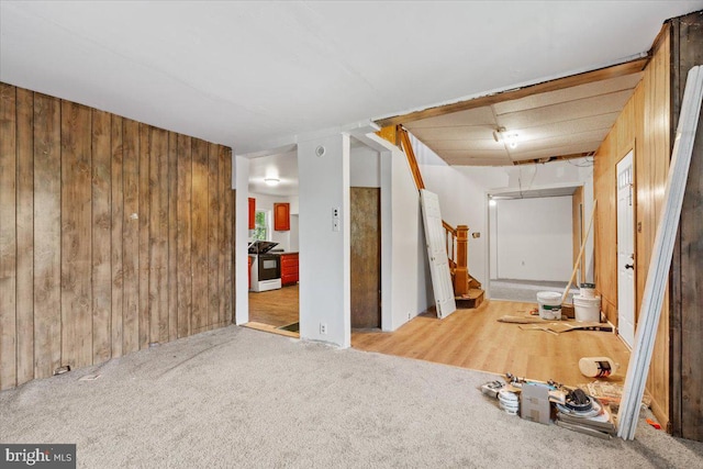 corridor with light carpet and wood walls