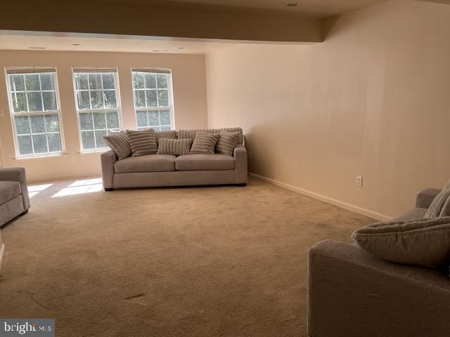 living room with light carpet and beam ceiling